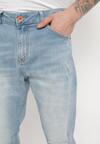 Niebieskie Dopasowane Jeansy z Przetarciami i Regularnym Stanem Kolora