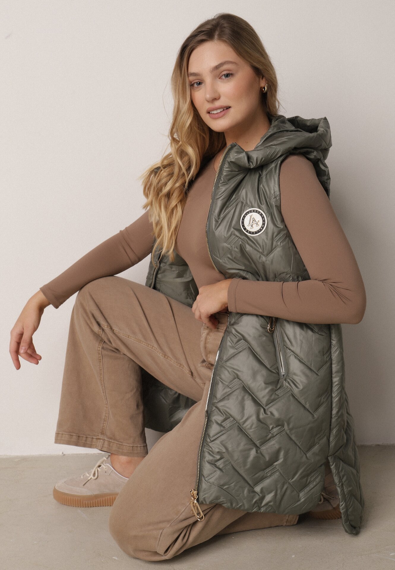 Zielona Przejściowa Kamizelka Pikowana o Długim Kroju z Kapturem i Naszywką Harmaste